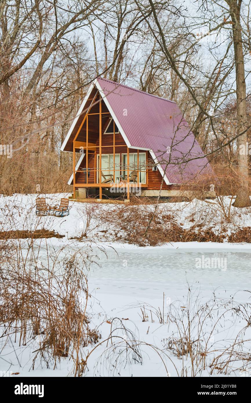 Particolare di cabina nei boschi durante l'inverno con lago ghiacciato Foto Stock