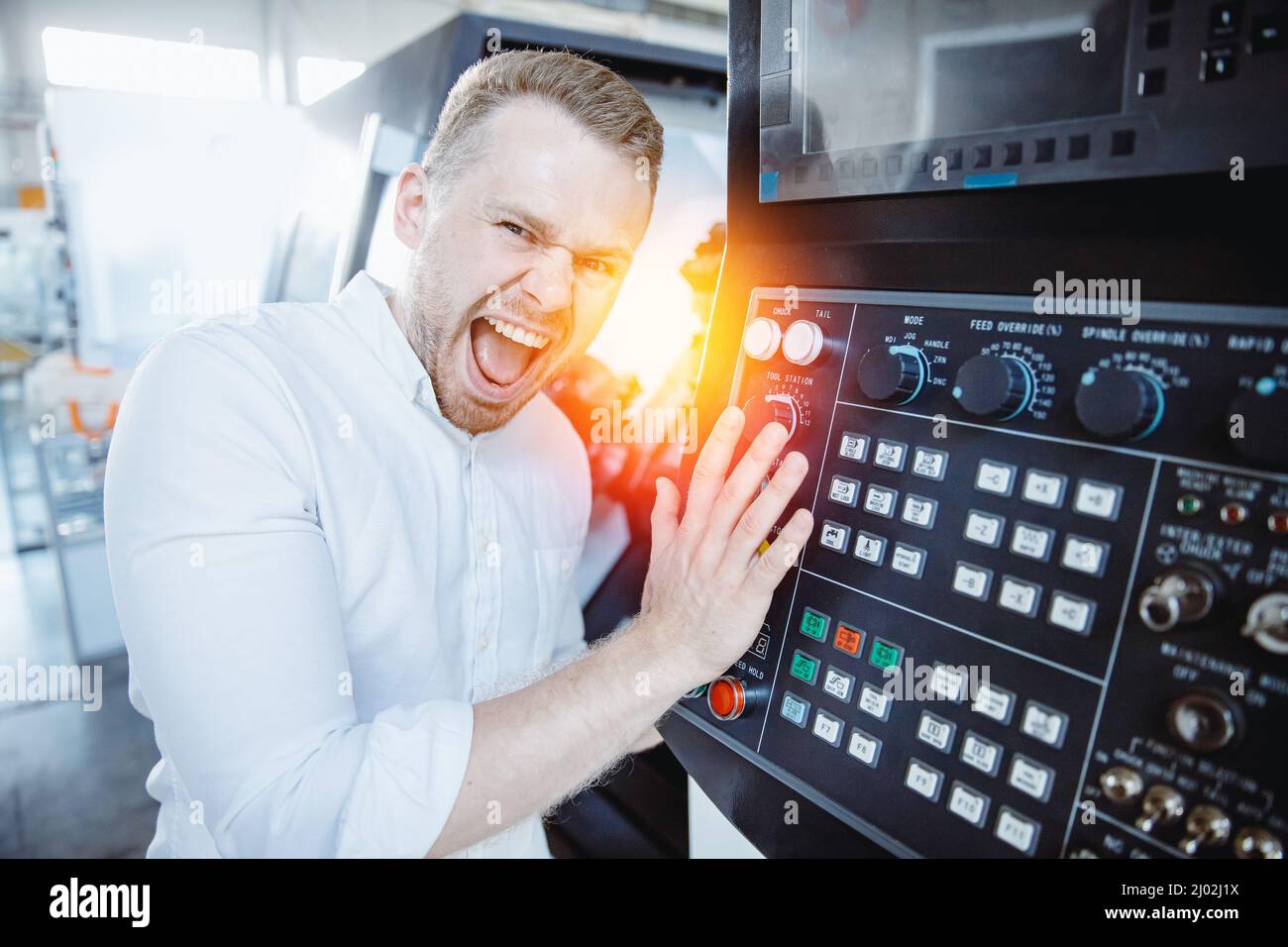 Impiegato del settore utilizzare il pulsante per l'intervento in caso di incidente sulla macchina sul pavimento della fabbrica. Foto Stock