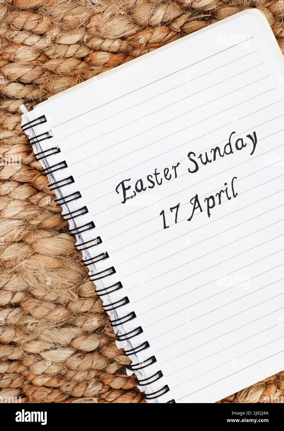 Pasqua Domenica 17 Aprile scritto a mano su un quaderno con sfondo rustico Foto Stock