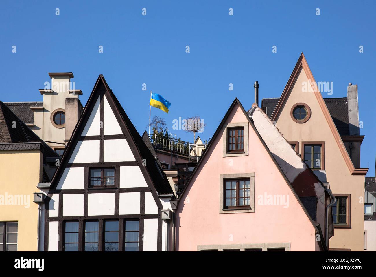 In solidarietà con l'Ucraina, la bandiera Ucraina sventola sui tetti della città vecchia, Colonia, Germania. 3 marzo 2022. Aus Solidaritaet mit der Ukr Foto Stock