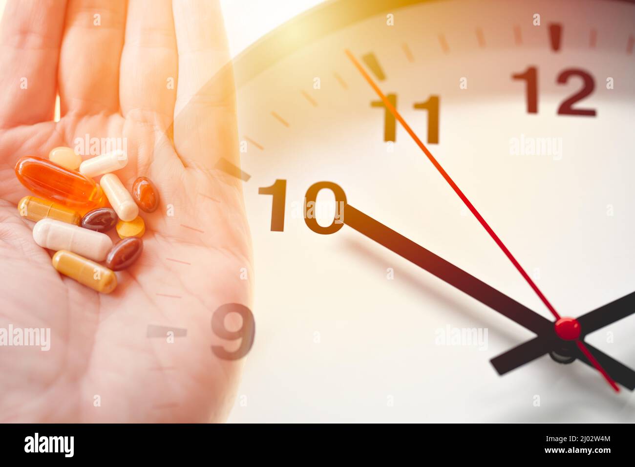 Ora del giorno per prendere un farmaco multi-dose concetto di farmaco. Varie pillole di medicina assortite tablet overlay orologio faccia. Foto Stock