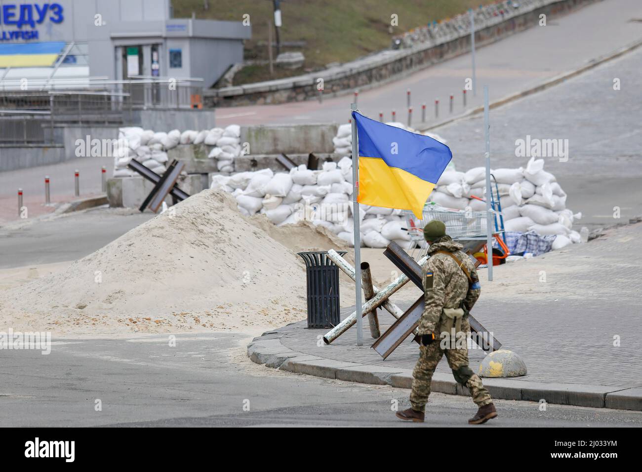 Kiev, Ucraina. 13th Mar 2022. Un soldato cammina sulla via Khereshchatyk dove c'è la bandiera Ucraina e un blocco stradale di sacchi di sabbia. Le forze militari russe hanno lanciato un'invasione su vasta scala dell'Ucraina dal febbraio 24th. Le forze russe stanno avanzando sulla capitale Ucraina e si ritiene che siano a circa 25 chilometri di distanza. (Credit Image: © Mohammad Javad Abjoushak/SOPA Images via ZUMA Press Wire) Foto Stock