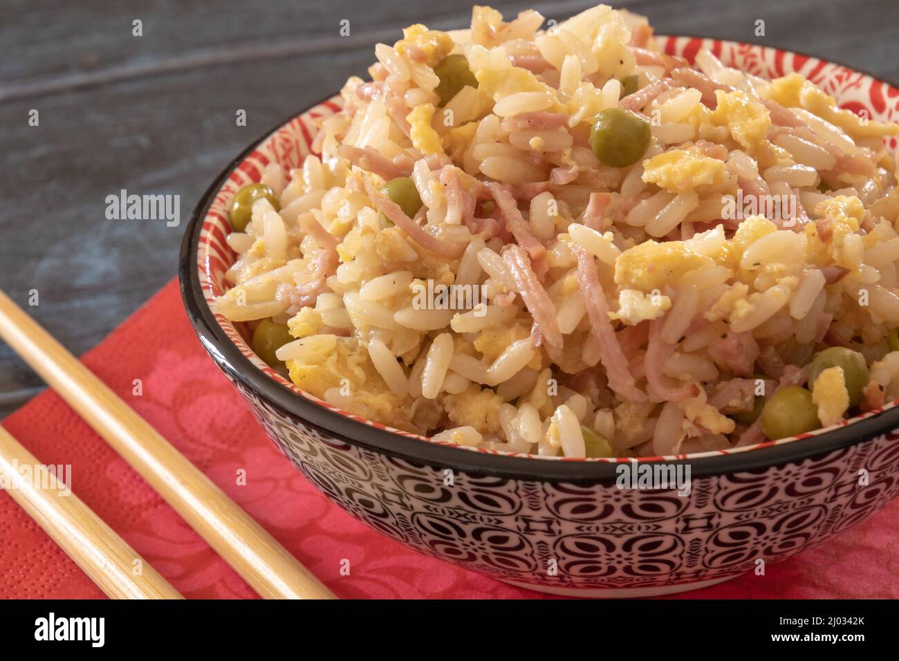 Riso cantonese in un recipiente con bacchette Foto Stock
