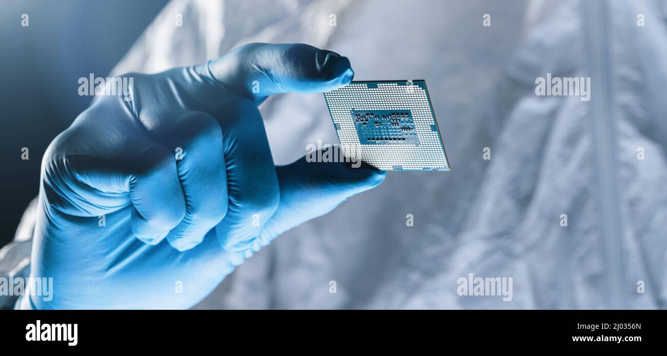 I guanti sono in possesso di microelettronica per test Microchip presso una fabbrica di produzione elettronica ultramoderno Foto Stock