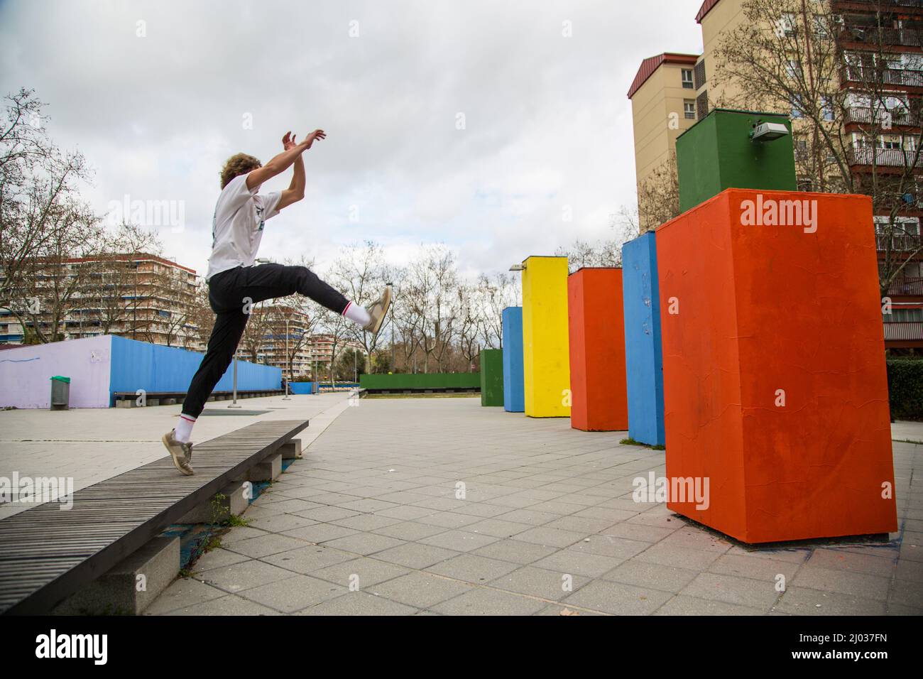 serie di foto di giovane uomo che salta praticando parkour in strada saltando tra blocchi di colore Foto Stock