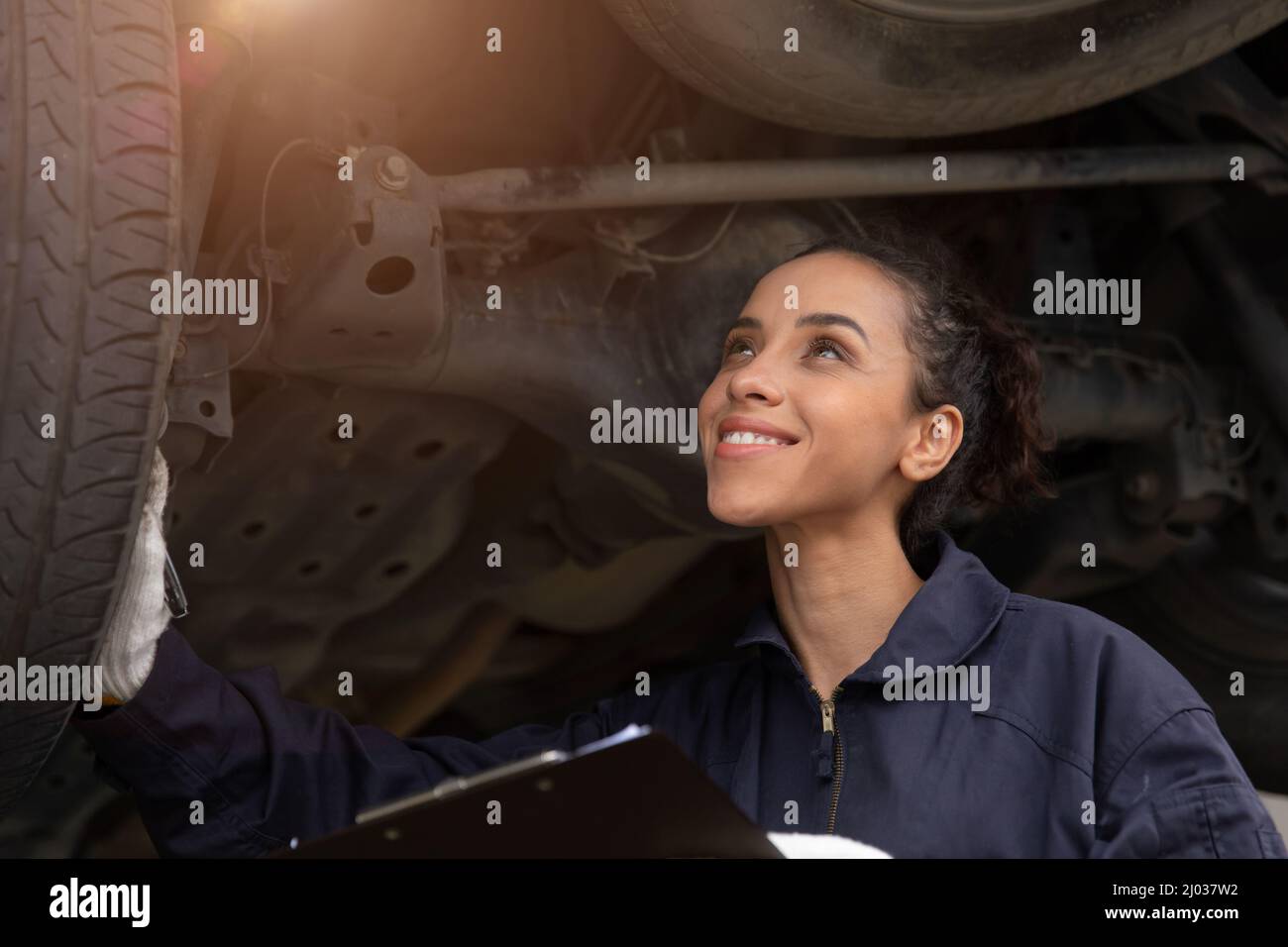 Felicità americana donna lavoratore nero. Il personale della signora meccanica controlla che l'auto funzioni nel garage dell'auto. Foto Stock