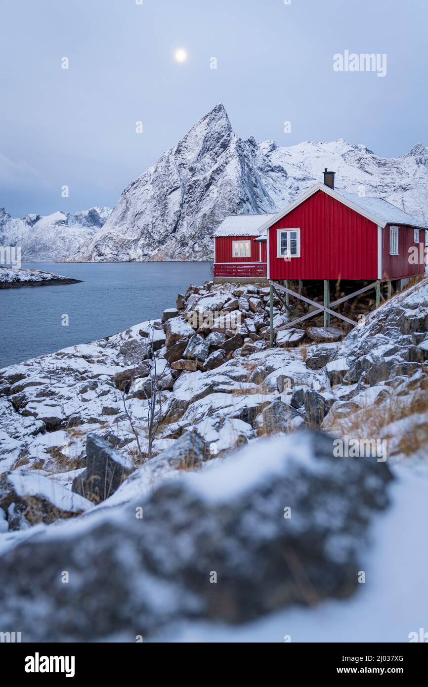 Cabine rosse di pescatori innevate al crepuscolo, Hamnoy, contea del Nordland, Isole Lofoten, Norvegia, Scandinavia, Europa Foto Stock