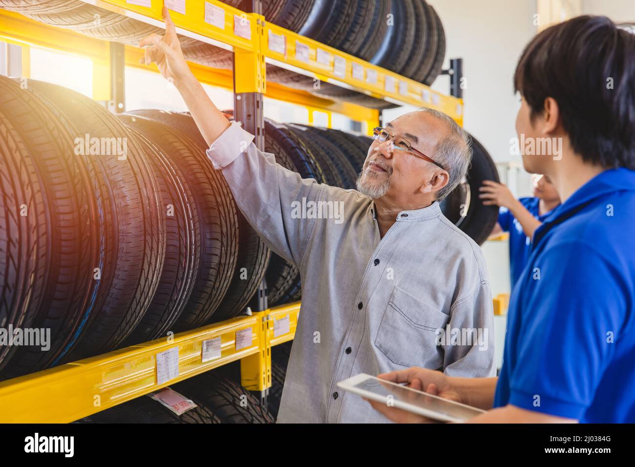 Vecchio uomo selezione del cliente pneumatico auto nel negozio di pneumatici garage Happy shopping Foto Stock