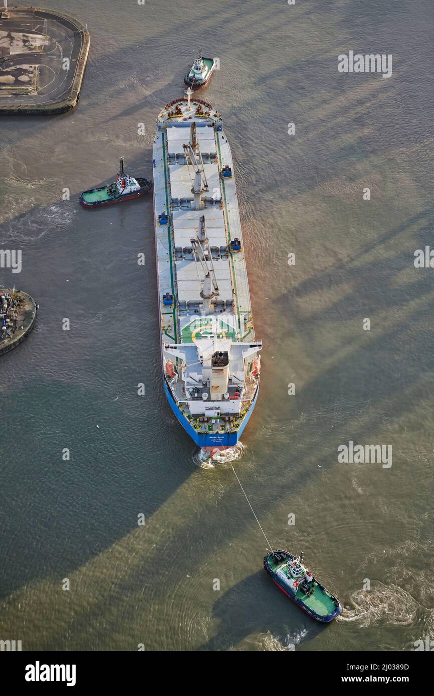 Attracco della nave a Seaforth Docks, Liverpool, essendo manovrato da due rimorchiatori, Merseyside, North West England, UK Foto Stock
