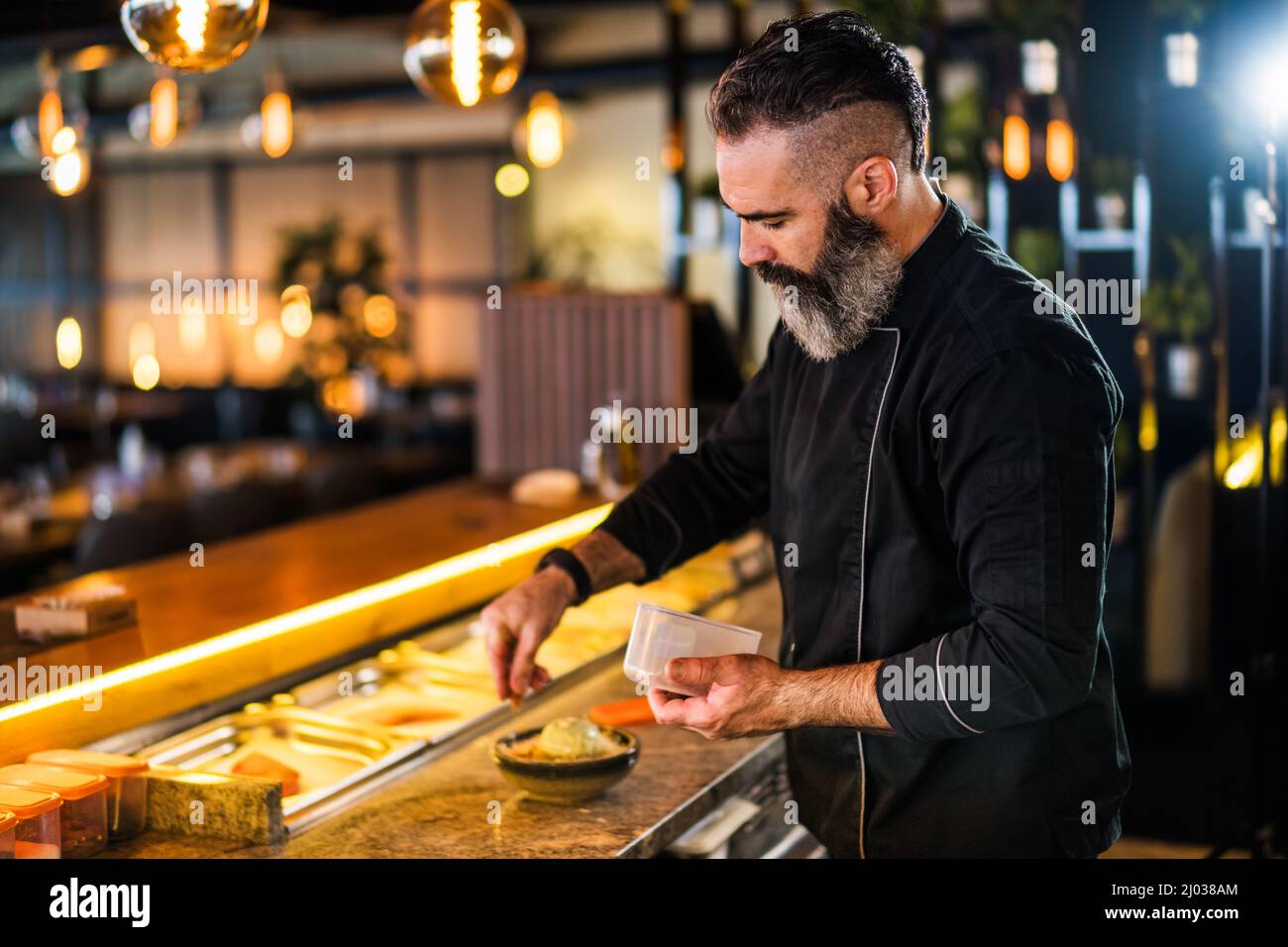 Il sushi chef prepara il dessert al sushi bar. Foto Stock
