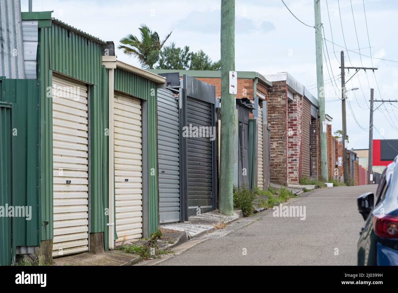 Porte garage porta a rulli anteriori in acciaio (stagno) capannoni e garage in mattoni in una corsia posteriore a St Peters, un centro ovest, sobborgo della città di Sydney, NSW, Australia Foto Stock