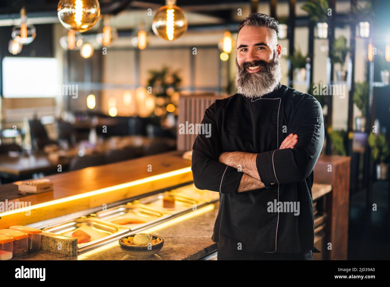 Ritratto di allegro chef sushi al ristorante sushi. Sta mostrando i pollici in su. Foto Stock