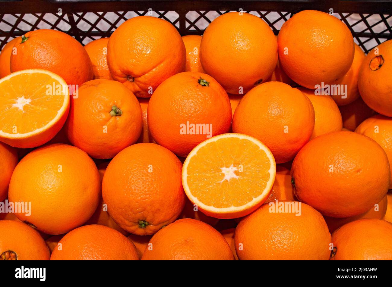 Arance tagliate a metà in un mucchio di altri Foto Stock