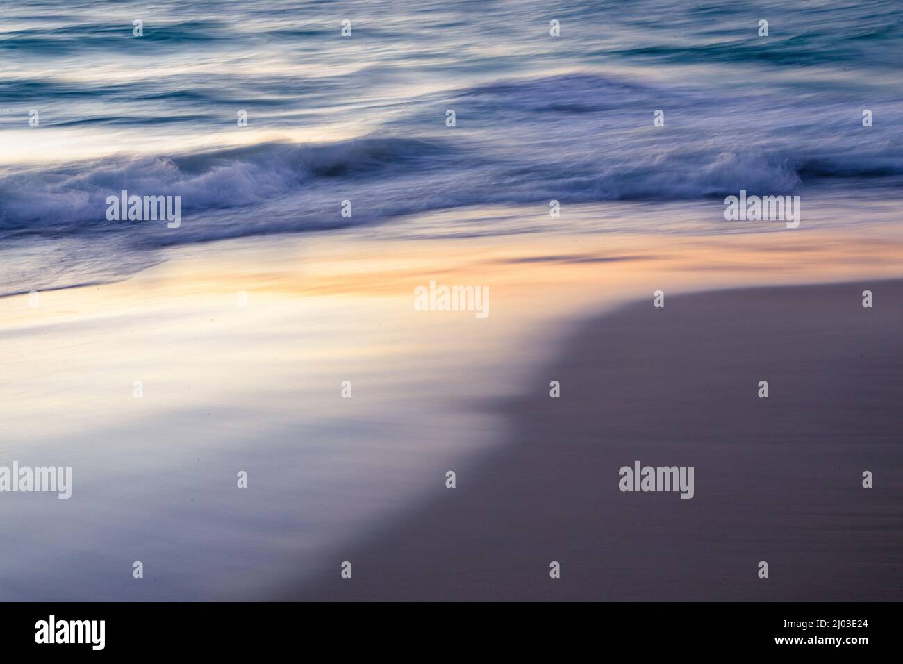 Tramonto, onde che si avvolgono a Yanchep Beach, Australia Occidentale Foto Stock