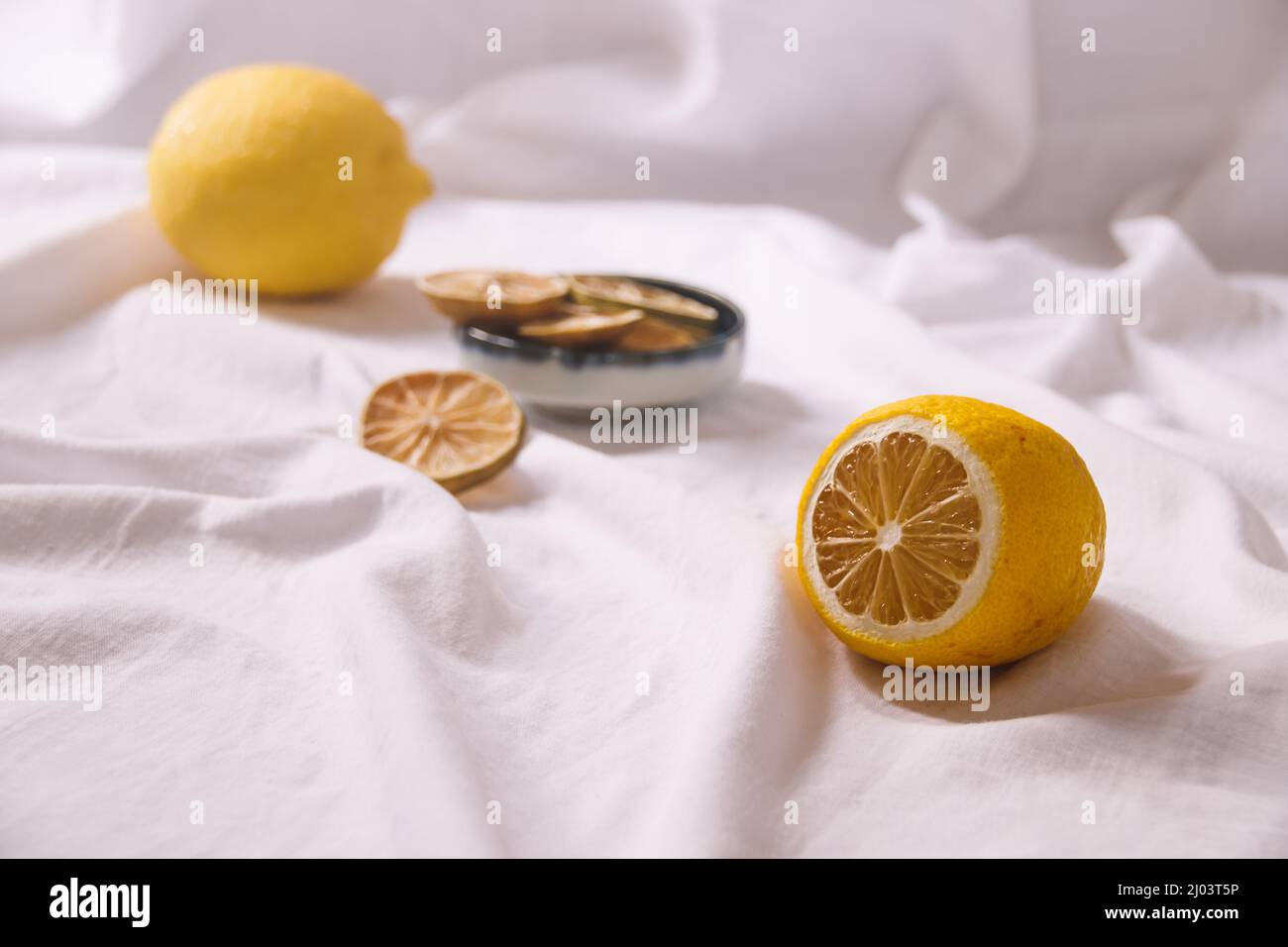 Vita morta minimalista di limoni freschi e secchi che mostrano il concetto di freschezza, estetica estiva e vita sana e sostenibile Foto Stock