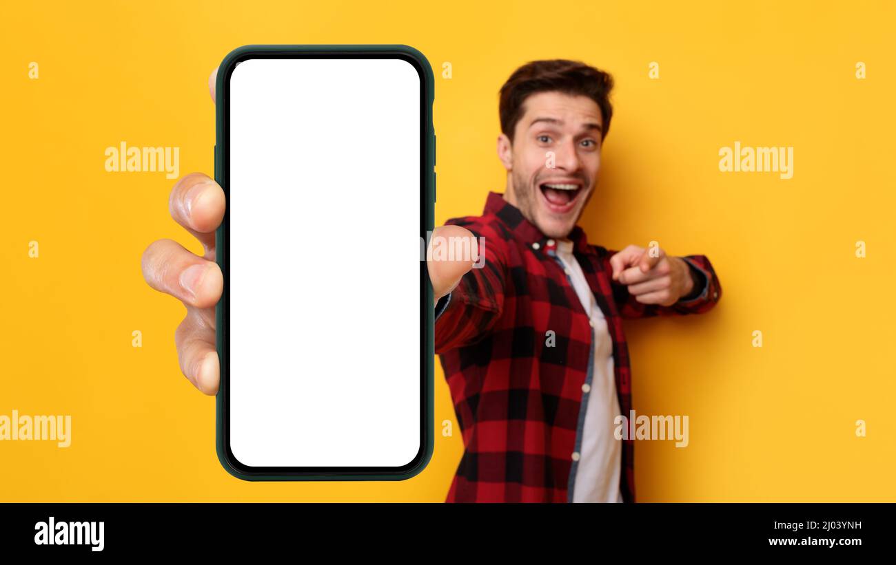 Ragazzo eccitato che punta sullo schermo bianco vuoto dello smartphone Foto Stock