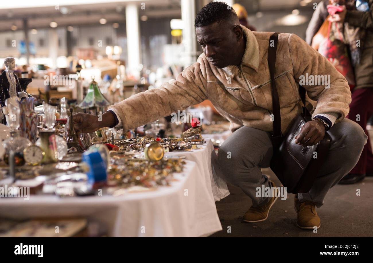Il ragazzo Afro-Americano ordinario considera le cose saconde mani sul mercato delle pulci Foto Stock