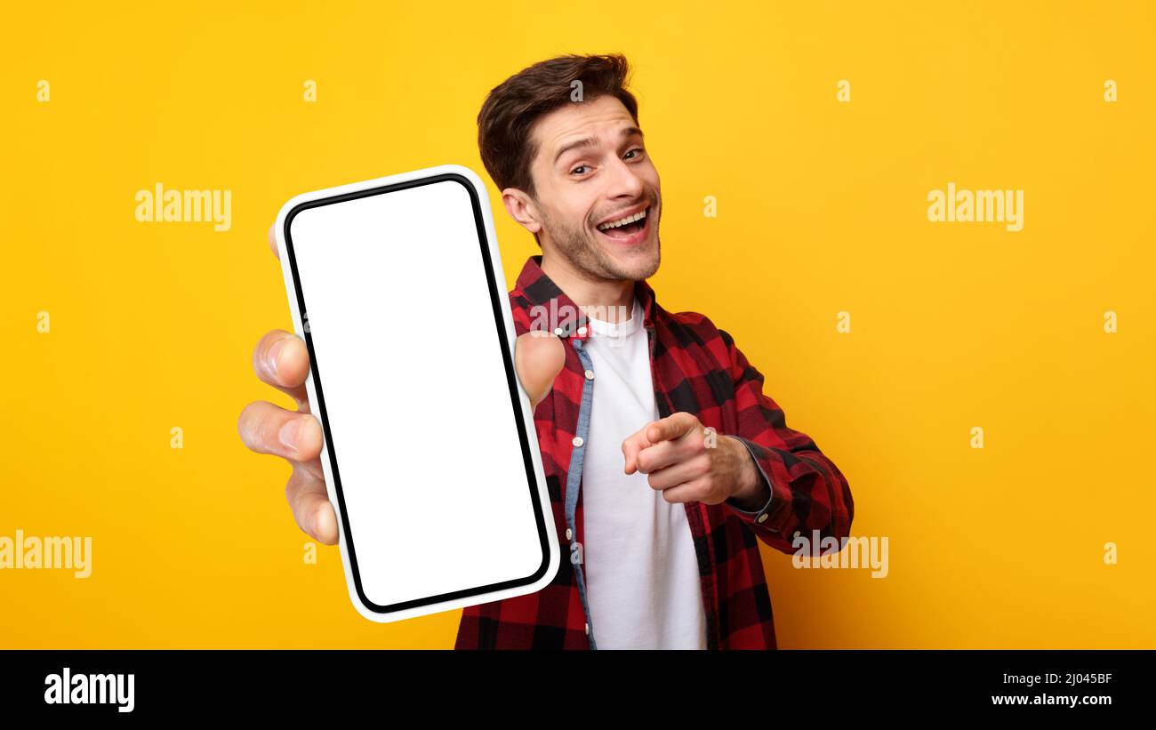 Ragazzo eccitato che punta sullo schermo bianco vuoto dello smartphone Foto Stock