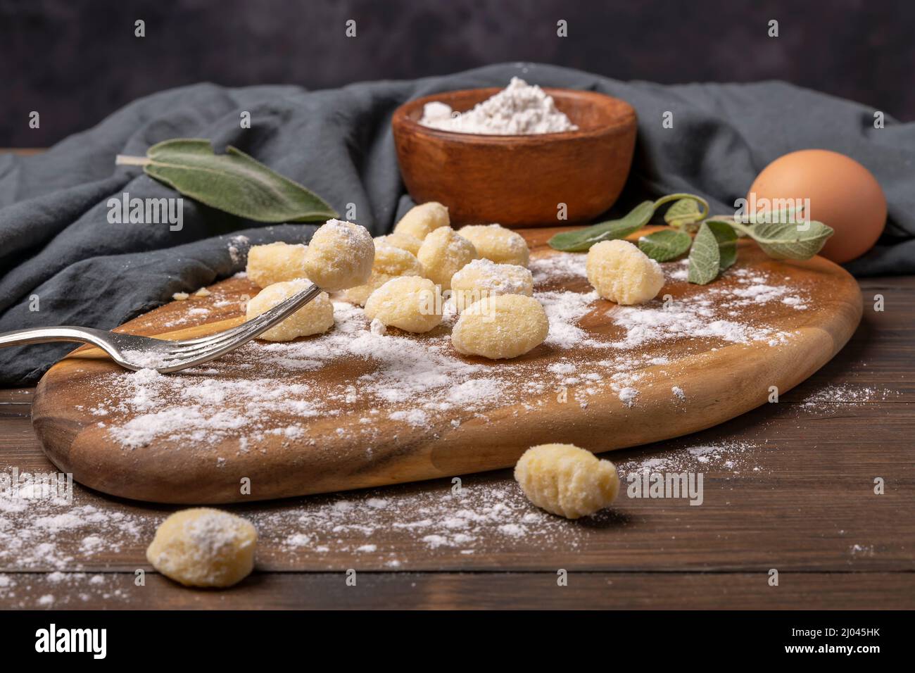 Gnocchi di patate e di farina, pasta tipica italiana su un tagliere di legno con foglie di salvia Foto Stock