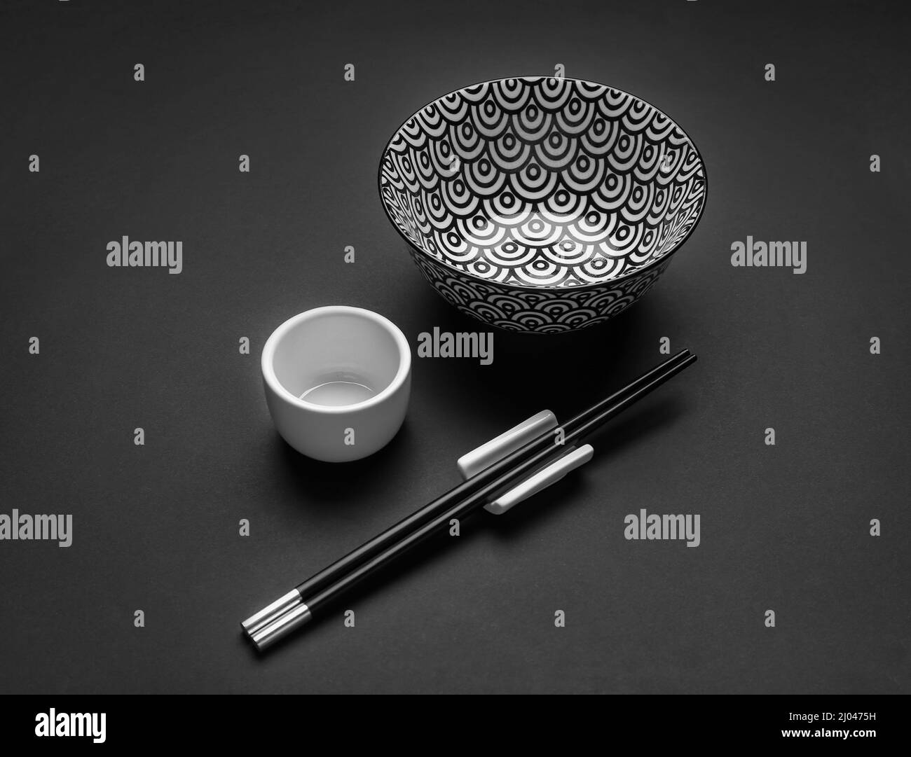 Ciotole cinesi con bacchette su sfondo scuro Foto Stock