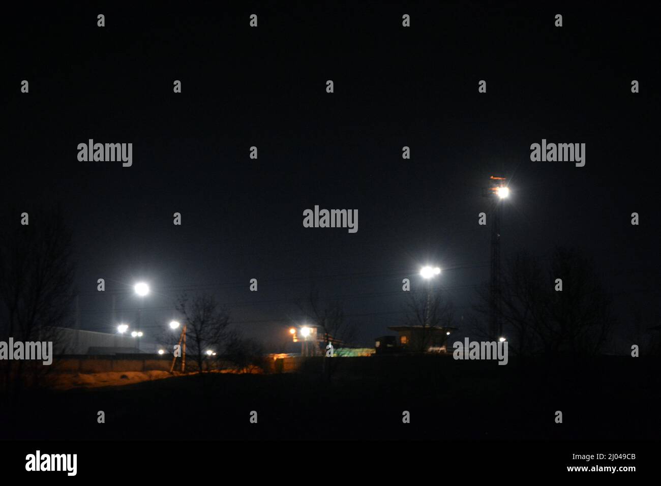 Zona industriale, colline e montagne di scorie grigie, residui dell'industria metallurgica, apparecchiature industriali e illuminazione industriale. Foto Stock