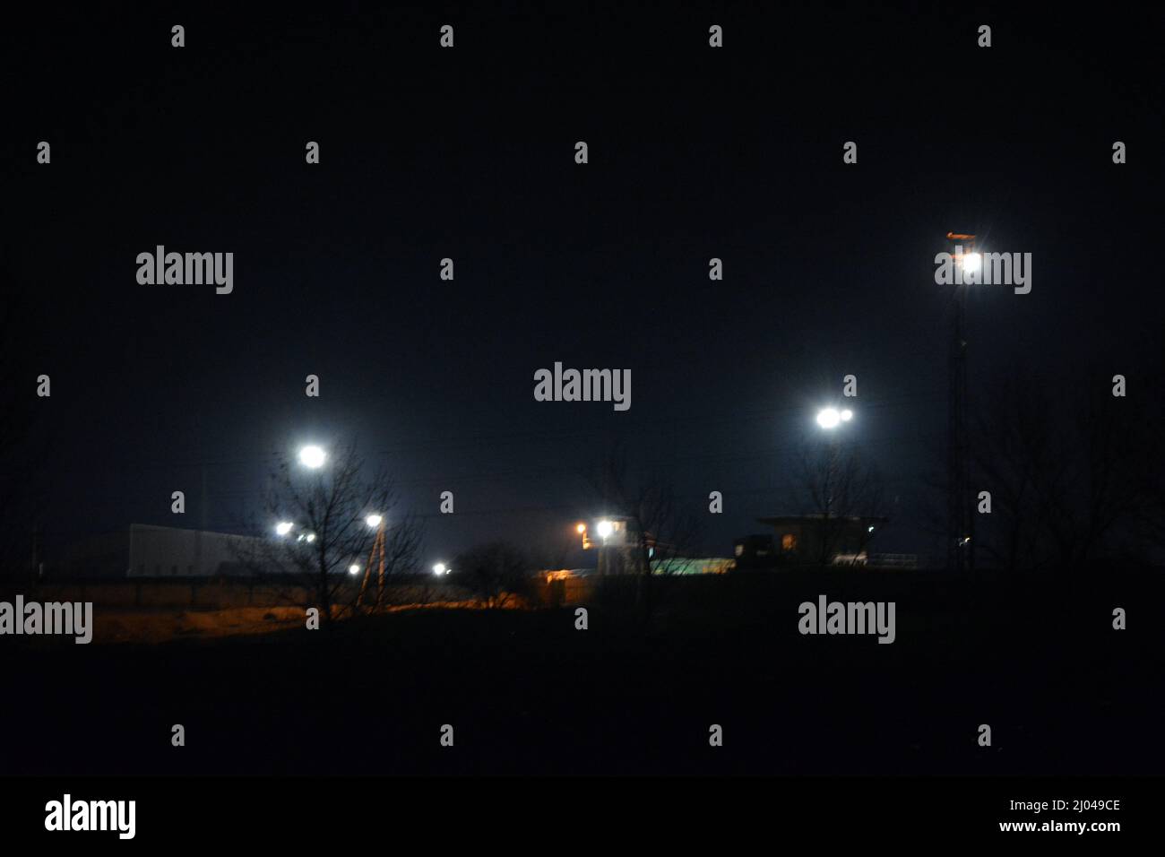 Zona industriale, colline e montagne di scorie grigie, residui dell'industria metallurgica, apparecchiature industriali e illuminazione industriale. Foto Stock