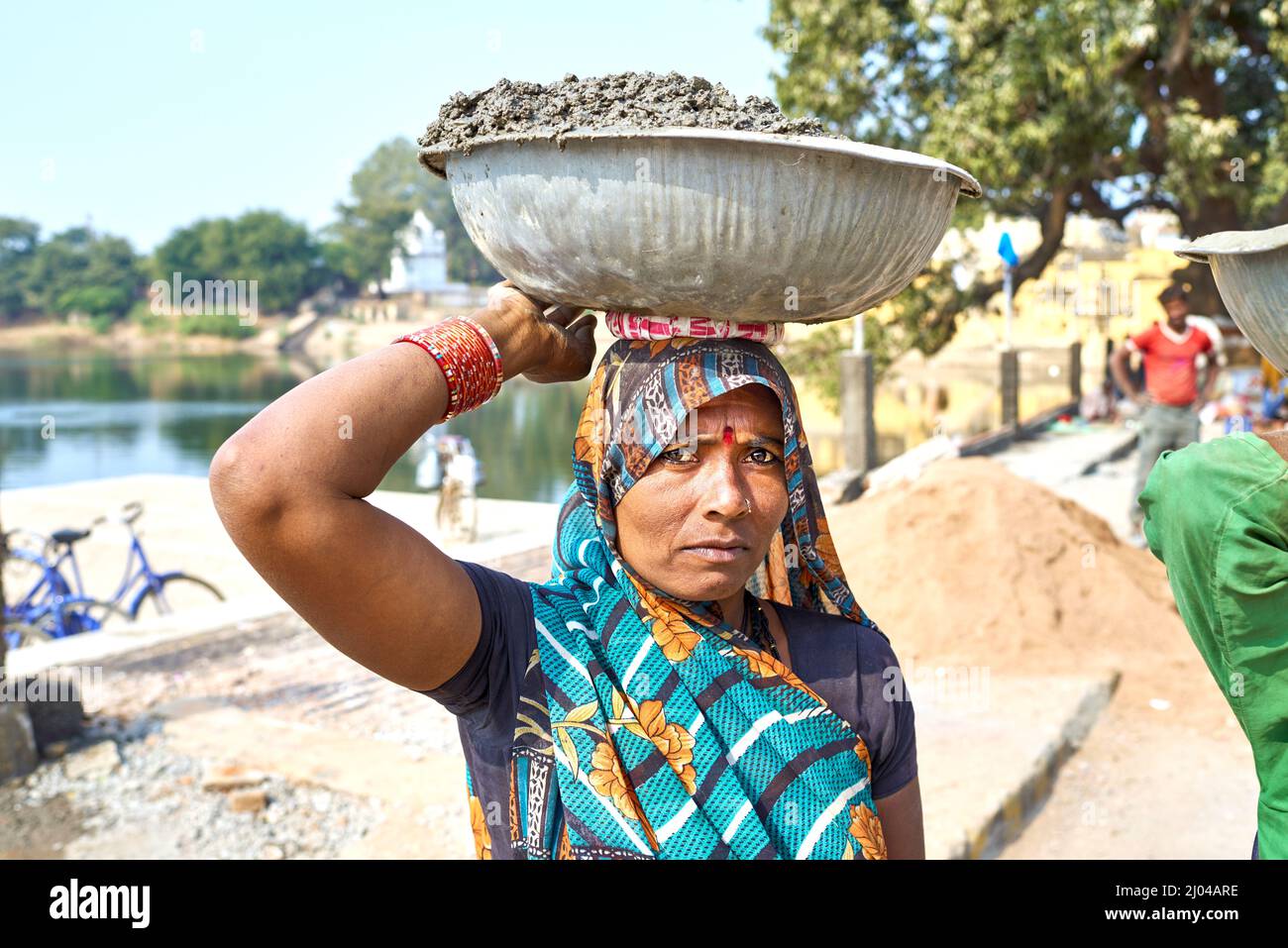 India. Varanasi. Una donna che porta un carico sopra la testa Foto Stock