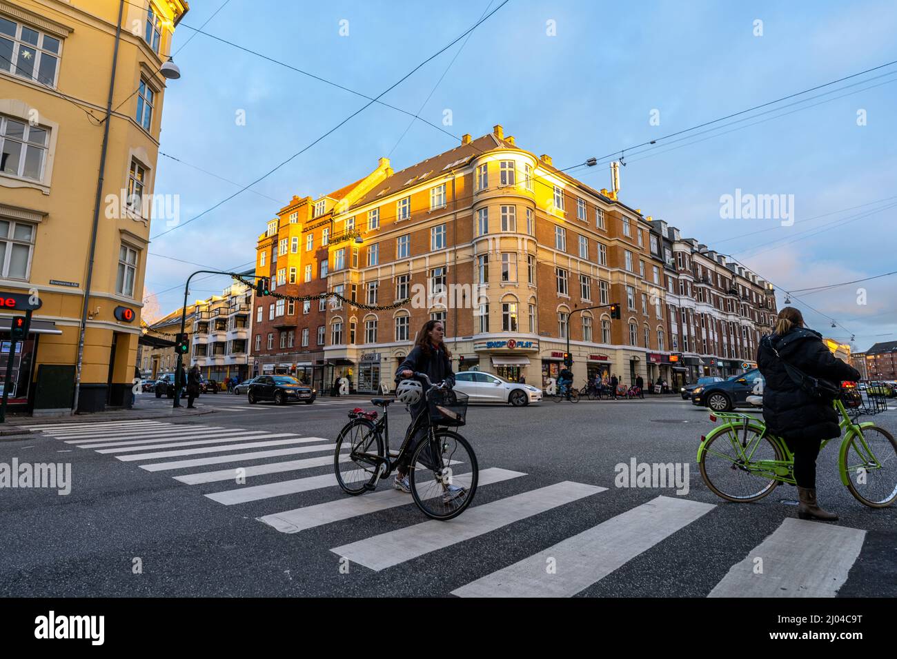 Automobili, edifici e persone con biciclette sul crosswalk a Copenhagen, Danimarca Foto Stock