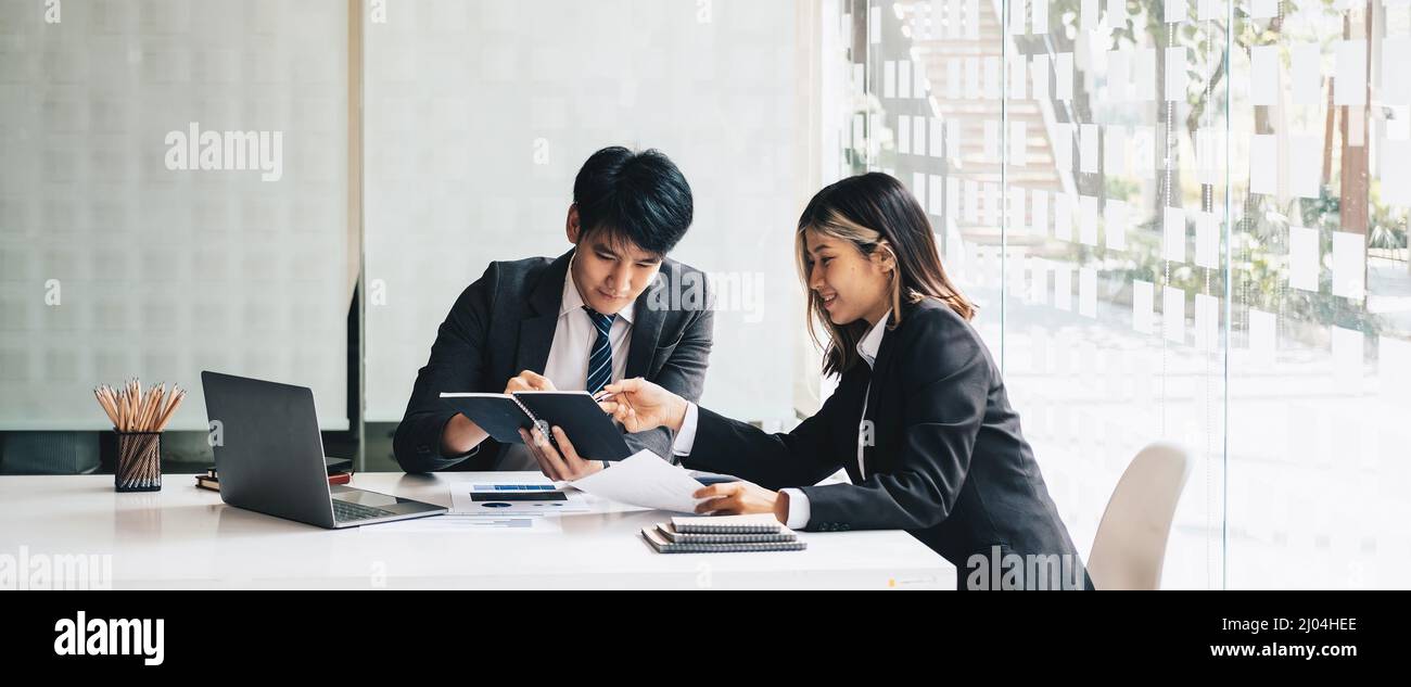 Giovane gruppo di affari asiatici con il lavoro creativo, parlare e scambiare idee condivise durante l'incontro. Business concetto di discussione finanziaria. Foto Stock
