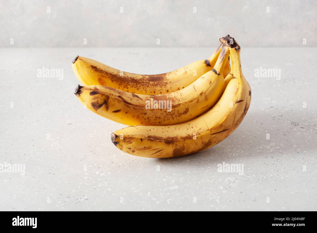 banane biologiche mature su fondo di cemento. concetto di cibo brutto zero rifiuti Foto Stock