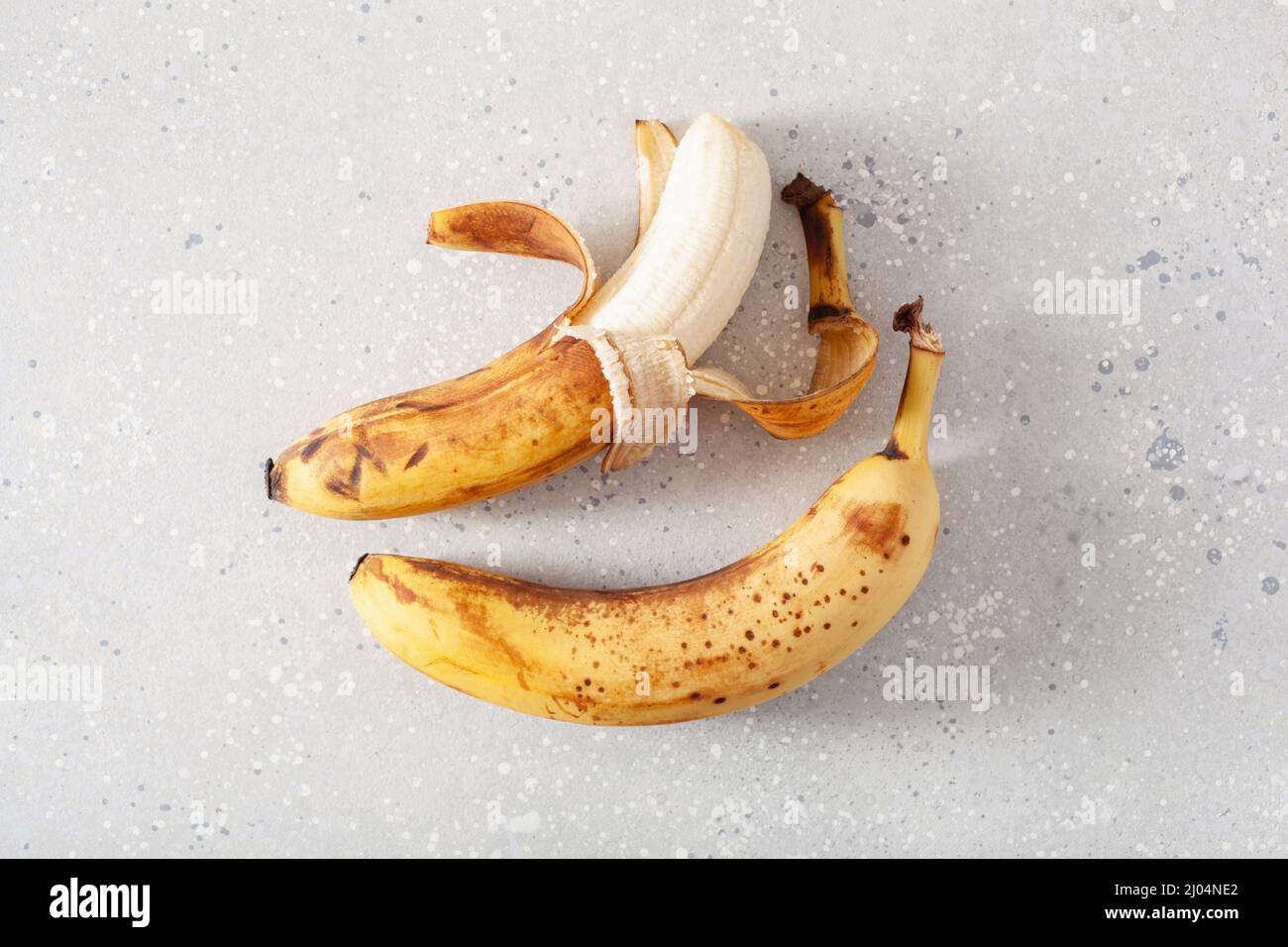 banane biologiche mature su fondo di cemento. concetto di cibo brutto zero rifiuti Foto Stock