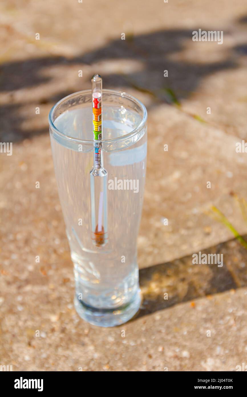 Un campione di liquore distillato di fresco, alcool in cilindro graduato di laboratorio. Foto Stock