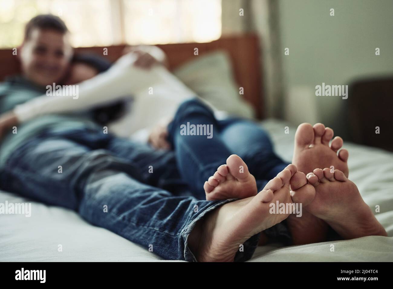 I miei piedi sono più comodi accanto ai tuoi. Shot di una coppia piedi come si stese sul letto. Foto Stock