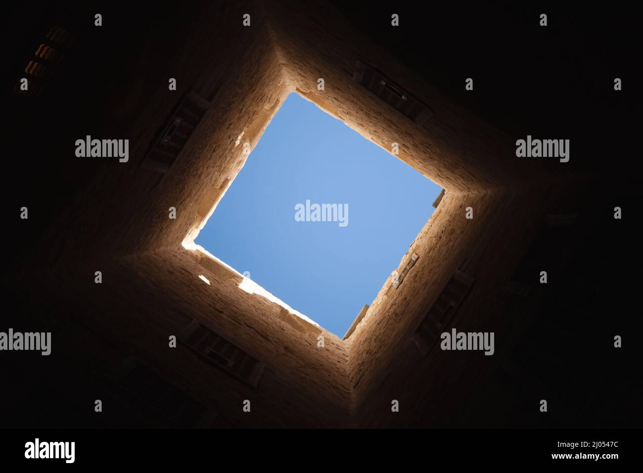 Finestra quadrata chiara all'interno della torre scura, astratto foto di sfondo architettonico scuro Foto Stock