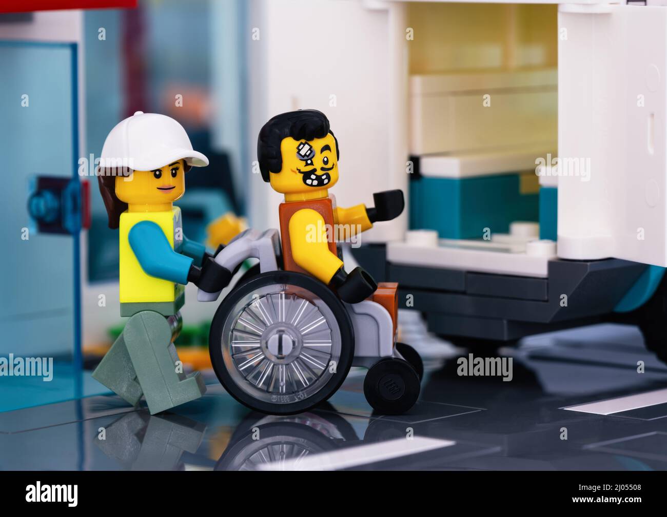 Tambov, Federazione Russa - 11 febbraio 2022 una minipfigura paramedica Lego  che spinge una sedia a rotelle con un paziente Lego seduto in un'ambulanza  Foto stock - Alamy