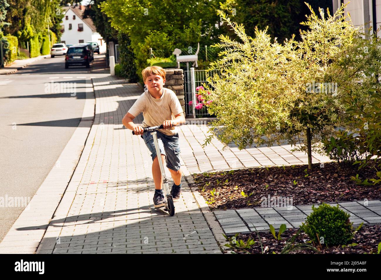 il ragazzo guida lo scooter sul paveway Foto Stock