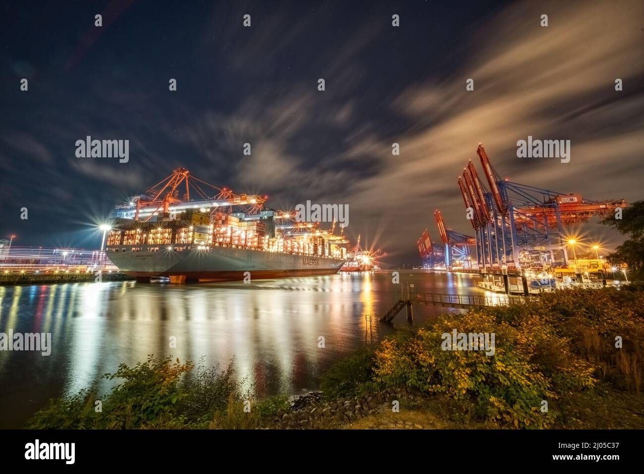Navi portacontainer nel porto di Amburgo di notte Foto Stock
