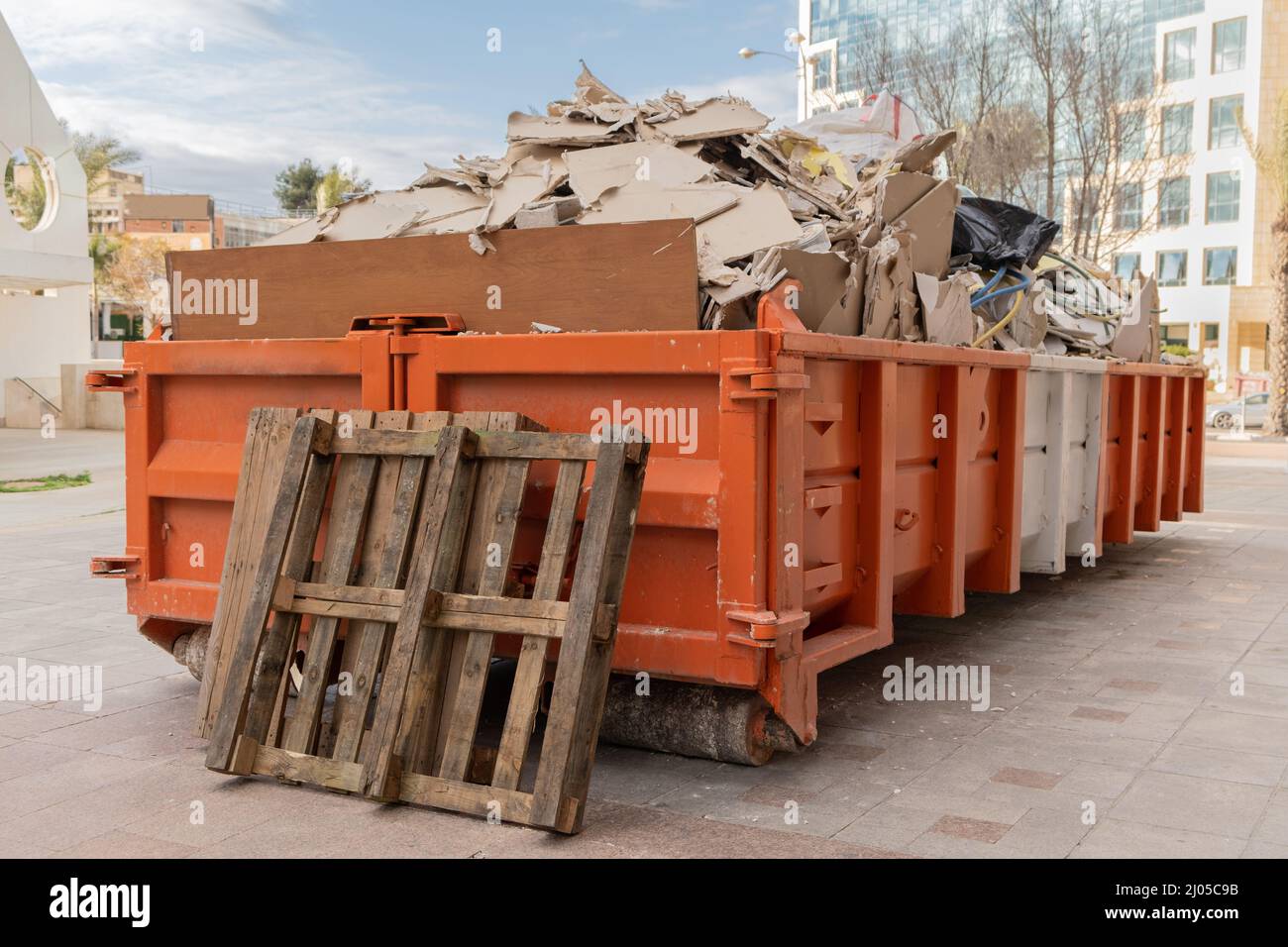 Enorme cumulo su metallo Grande contenitore di rifiuti di rifiuti di  dumpster sovraccaricato riempito con rifiuti di costruzione, cartongesso e  altre macerie vicino a un cantiere Foto stock - Alamy