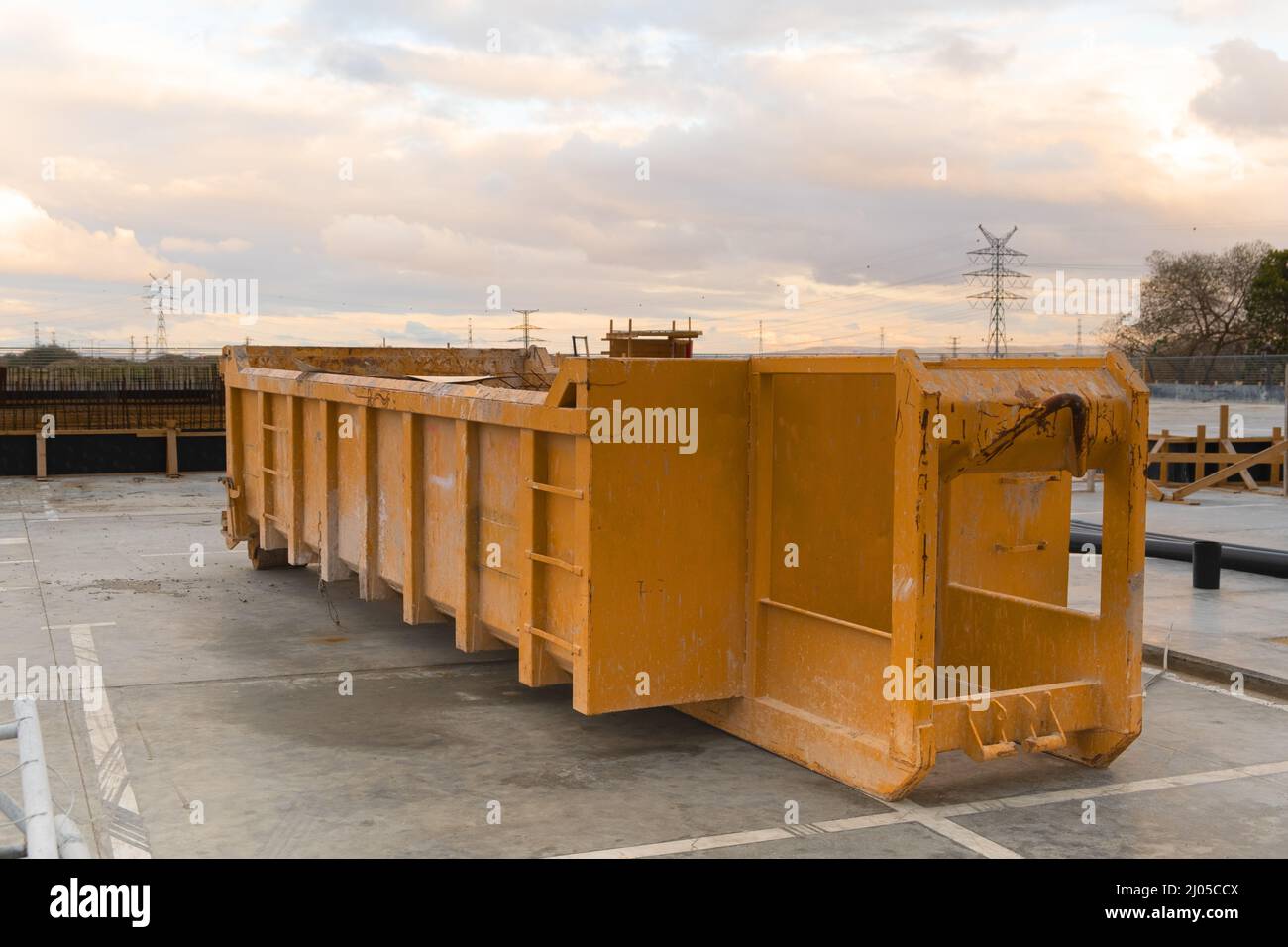 Grande enorme contenitore vuoto in metallo per rifiuti dumpster in costruzione vicino a un cantiere. Foto Stock
