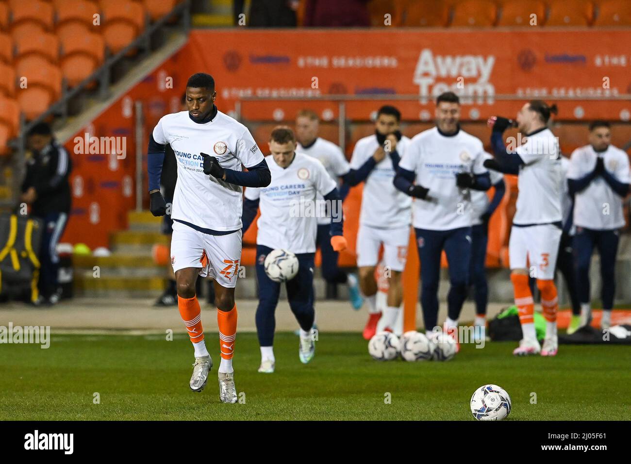 Marvin Ekpiteta #21 di Blackpool guida il suo lato fuori per durante il riscaldamento pre-partita in t shirt giovani caregivers giorno d'azione Foto Stock