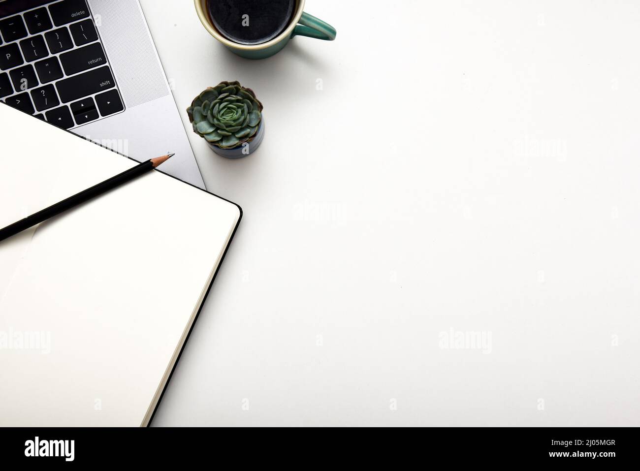 Configurazione della scrivania da ufficio per il lavoro domestico con il computer in linea un libro di note e bevande Foto Stock