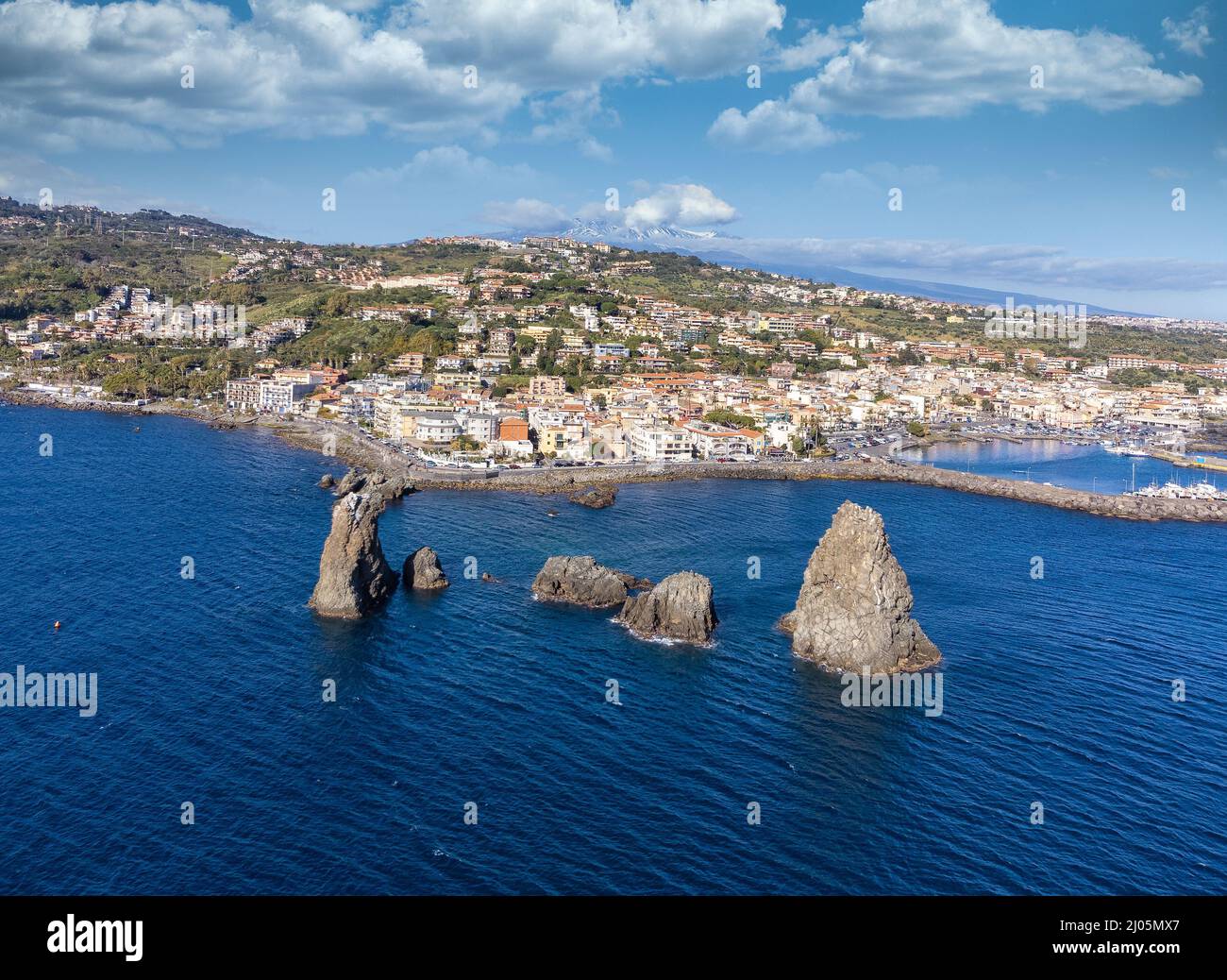 Vista aerea. Immagine del drone panoramico delle pile di Acitrezza con l'Etna sullo sfondo - destinazione del viaggio, Catania, Sicilia, Italia Foto Stock