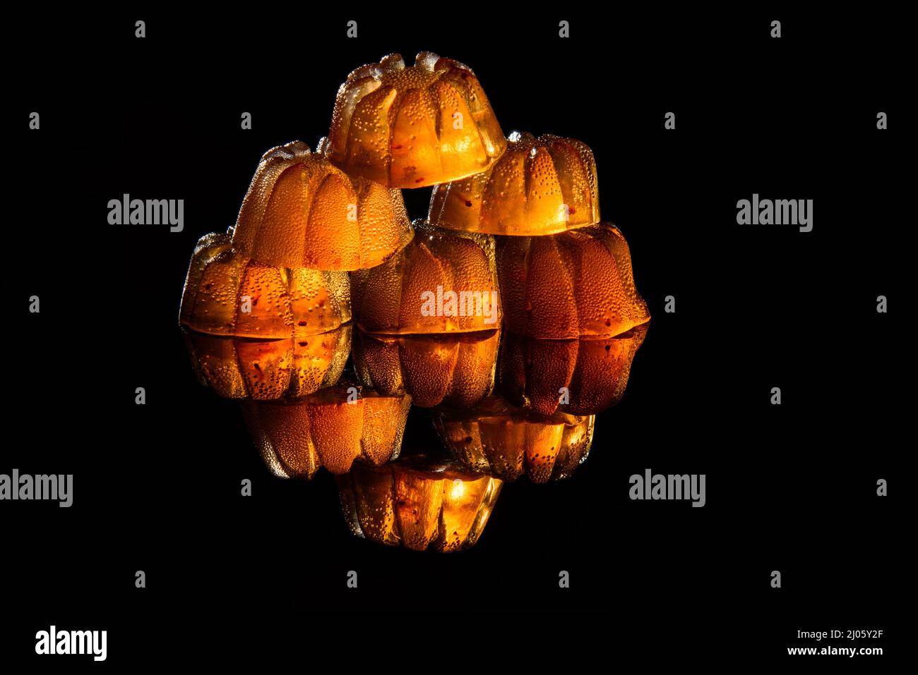 Marmellata di fragole trasparente su sfondo nero con riflessi. Foto Stock
