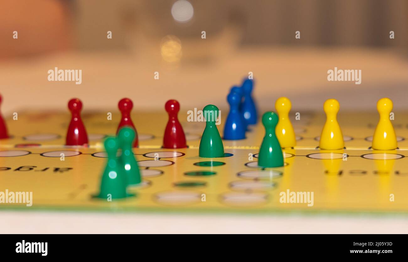 primo piano di un gioco da tavolo con pezzi di gioco colorati - mettere a fuoco su un pezzo di gioco con campo di profondità ridotto. Primo piano sfocato e sfondo sfocato Foto Stock