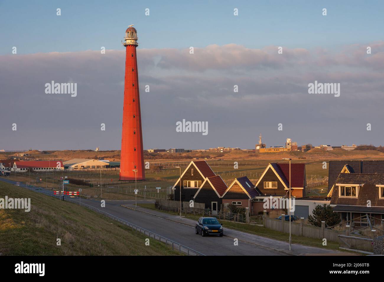 Vista del faro rosso chiamato Lange Jaap dal tramonto nel villaggio olandese Huisduinen Foto Stock