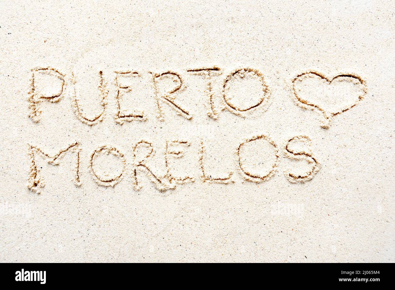 Scrivere a mano le parole 'Puerto Morelos' sulla sabbia della spiaggia Foto Stock