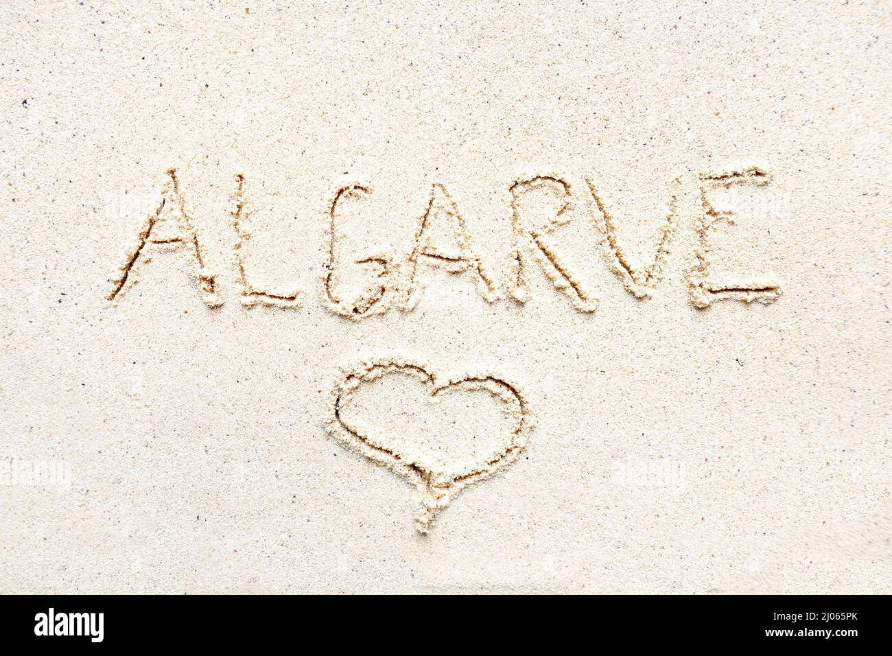 Scrivere a mano le parole 'Algarve' sulla sabbia della spiaggia Foto Stock