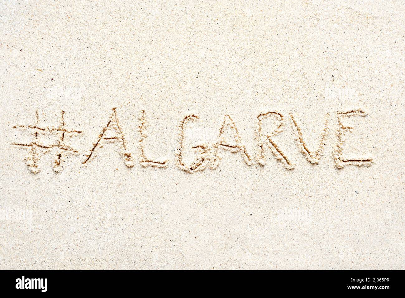 Scrivere a mano le parole 'Algarve' sulla sabbia della spiaggia Foto Stock