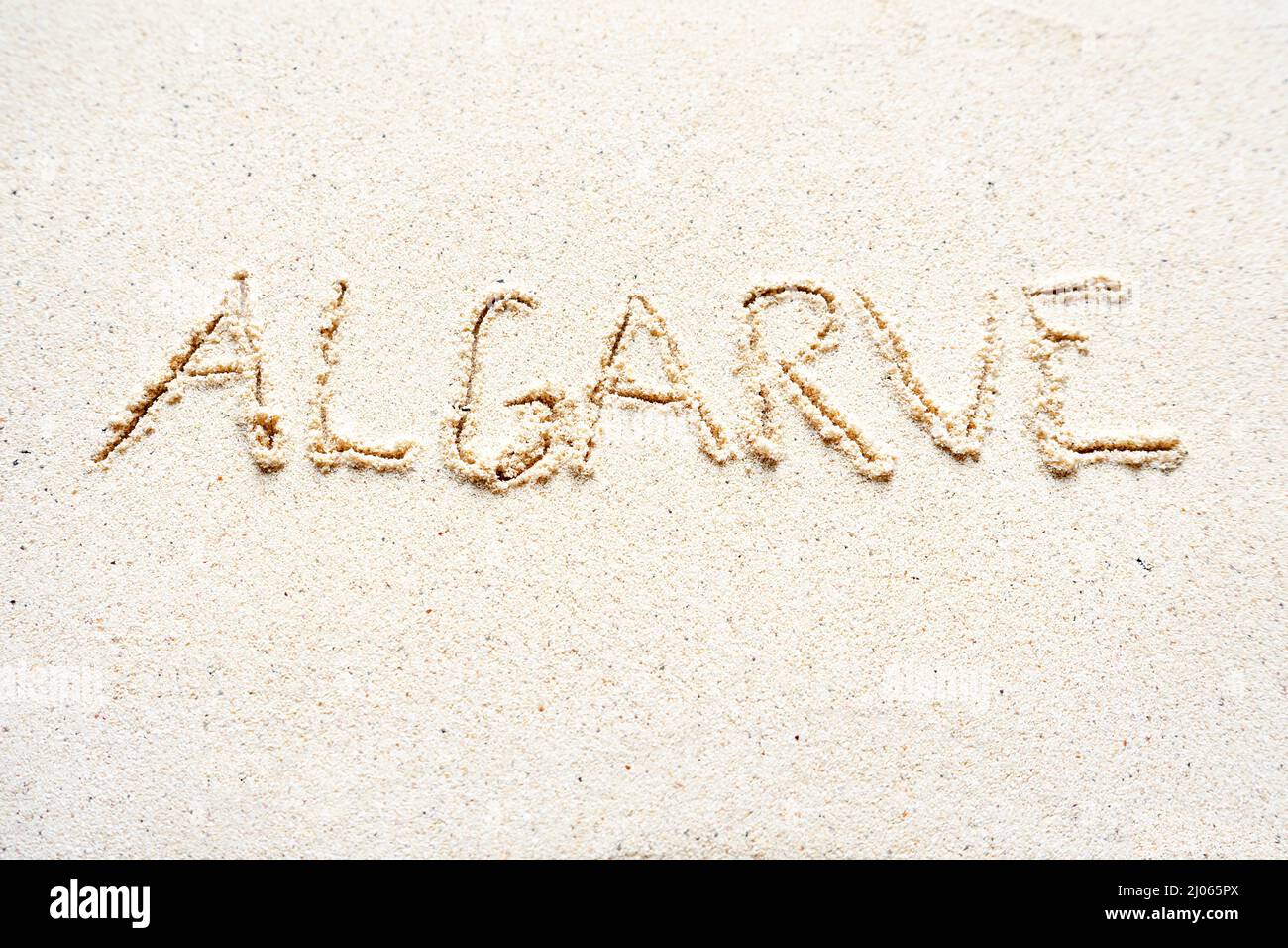 Scrivere a mano le parole 'Algarve' sulla sabbia della spiaggia Foto Stock