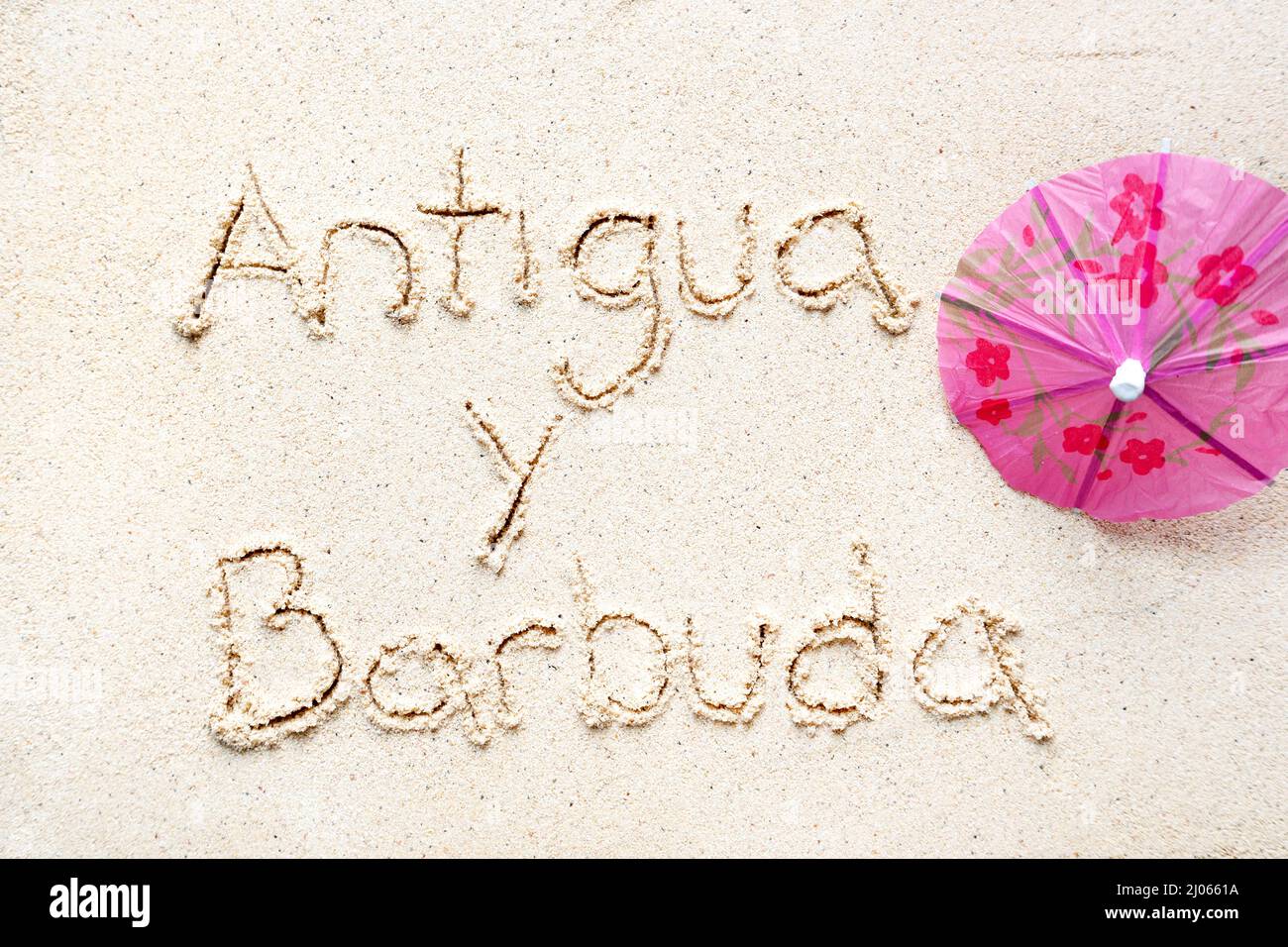 Scrivere a mano le parole 'Antigua y barbudaa' sulla sabbia della spiaggia Foto Stock